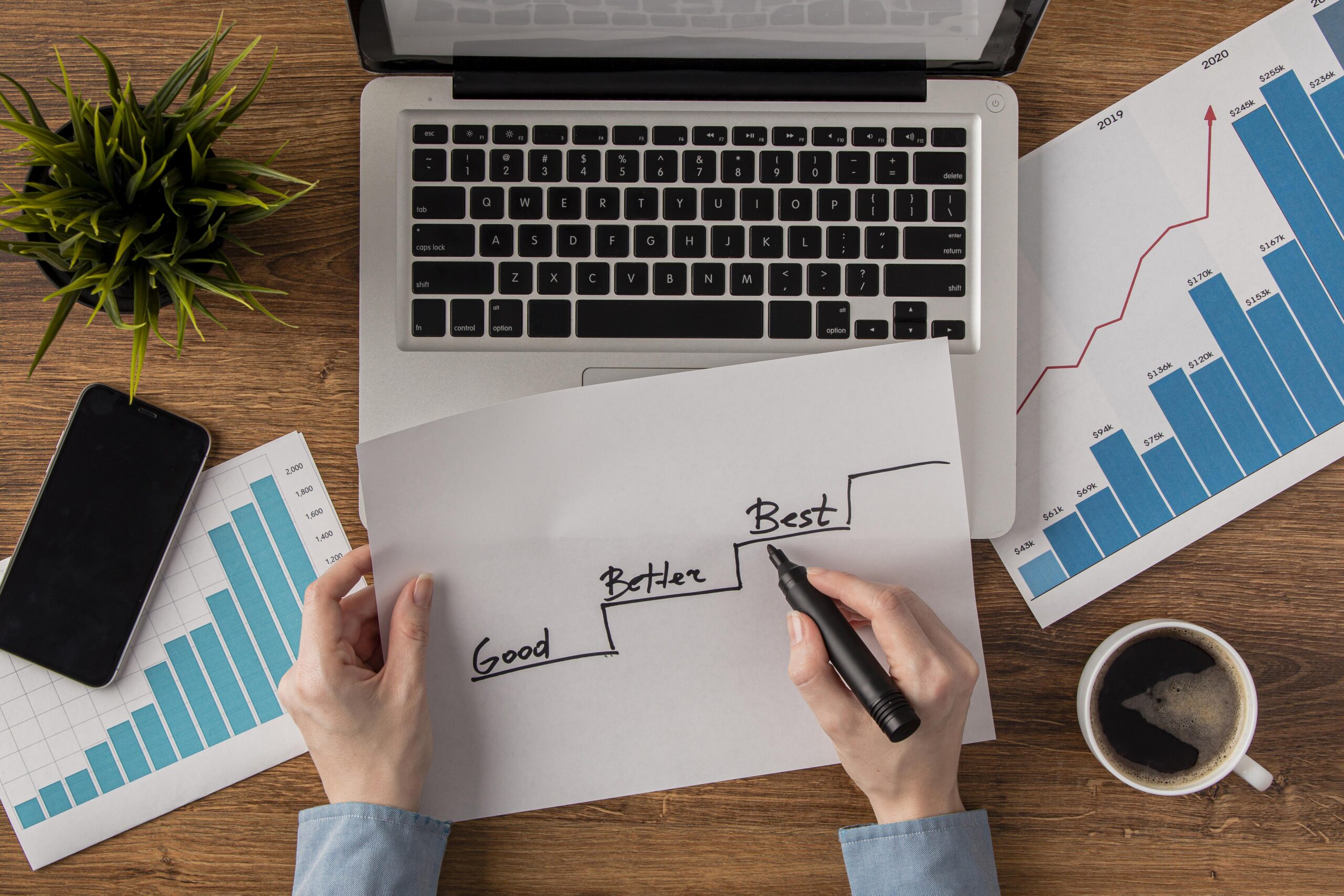 top-view-office-desk-with-growth-chart-held-by-hands