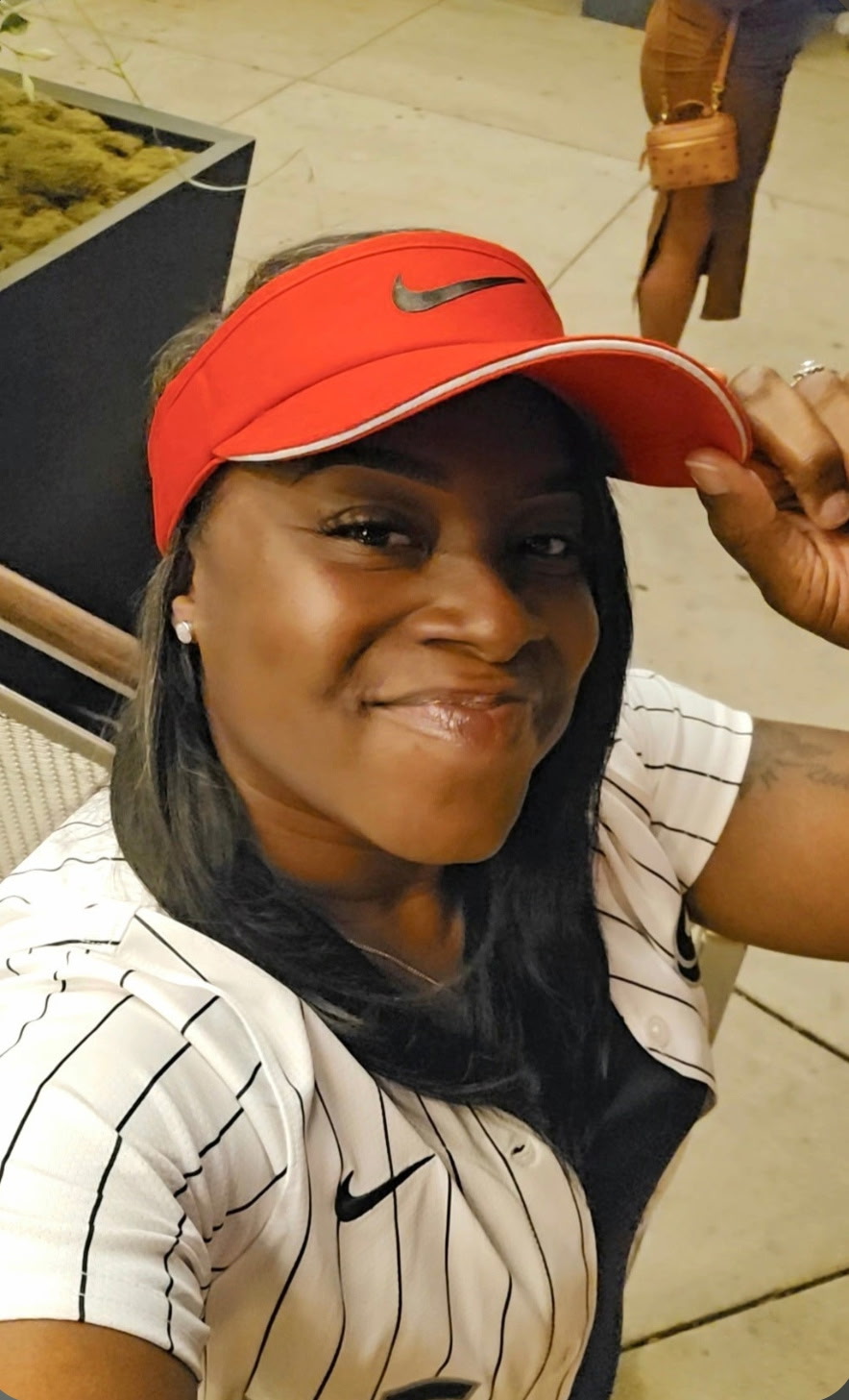 La'Aura Deluxe smiling in a red Nike visor, Chicago Minded entrepreneur birthday feature