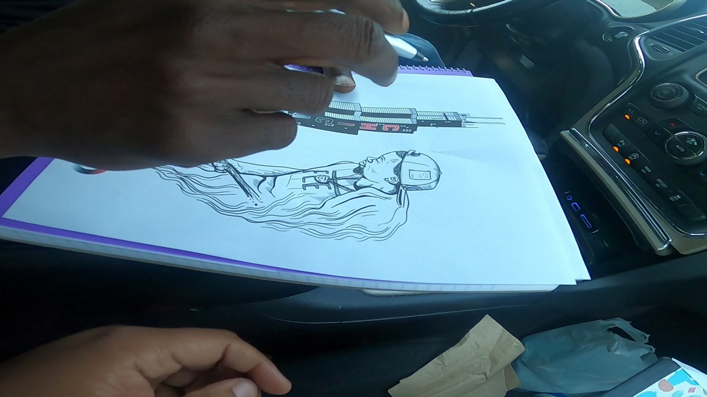 Hand drawing the custom chain design on a spiral notepad, a man with a shovel under the word MINDED