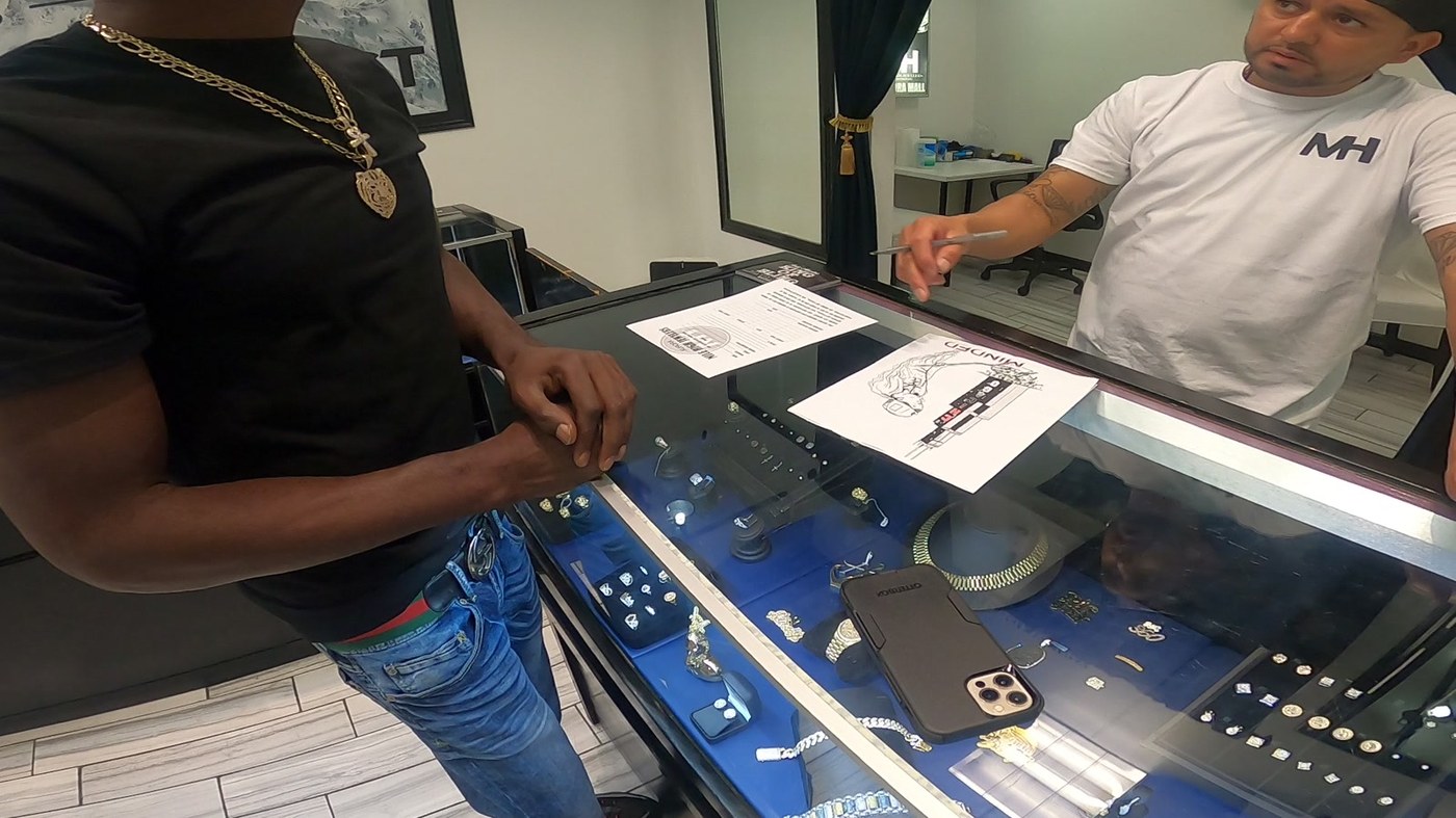 David Hawkins at the jewelry counter with the jeweler looking over the hand-drawn custom chain design