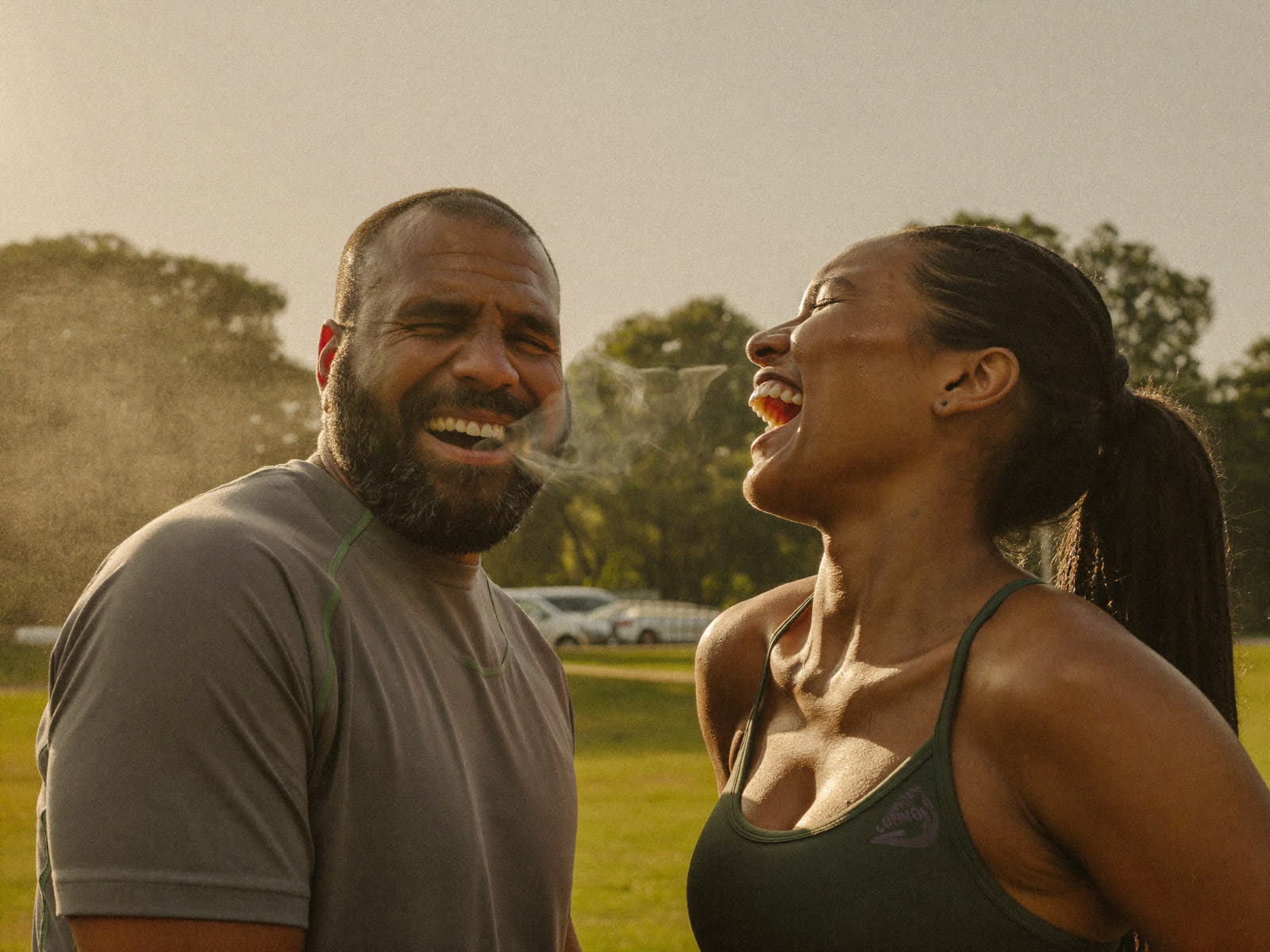 A couple laughing together outdoors after a workout
