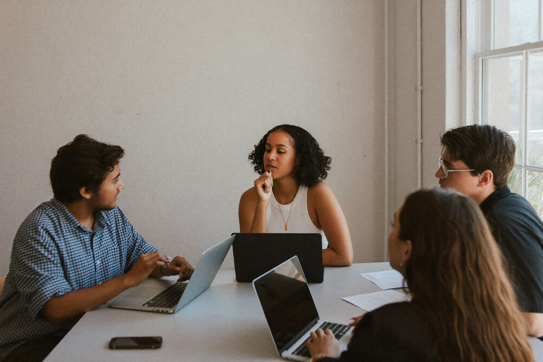 A small diverse team in conversation around a table