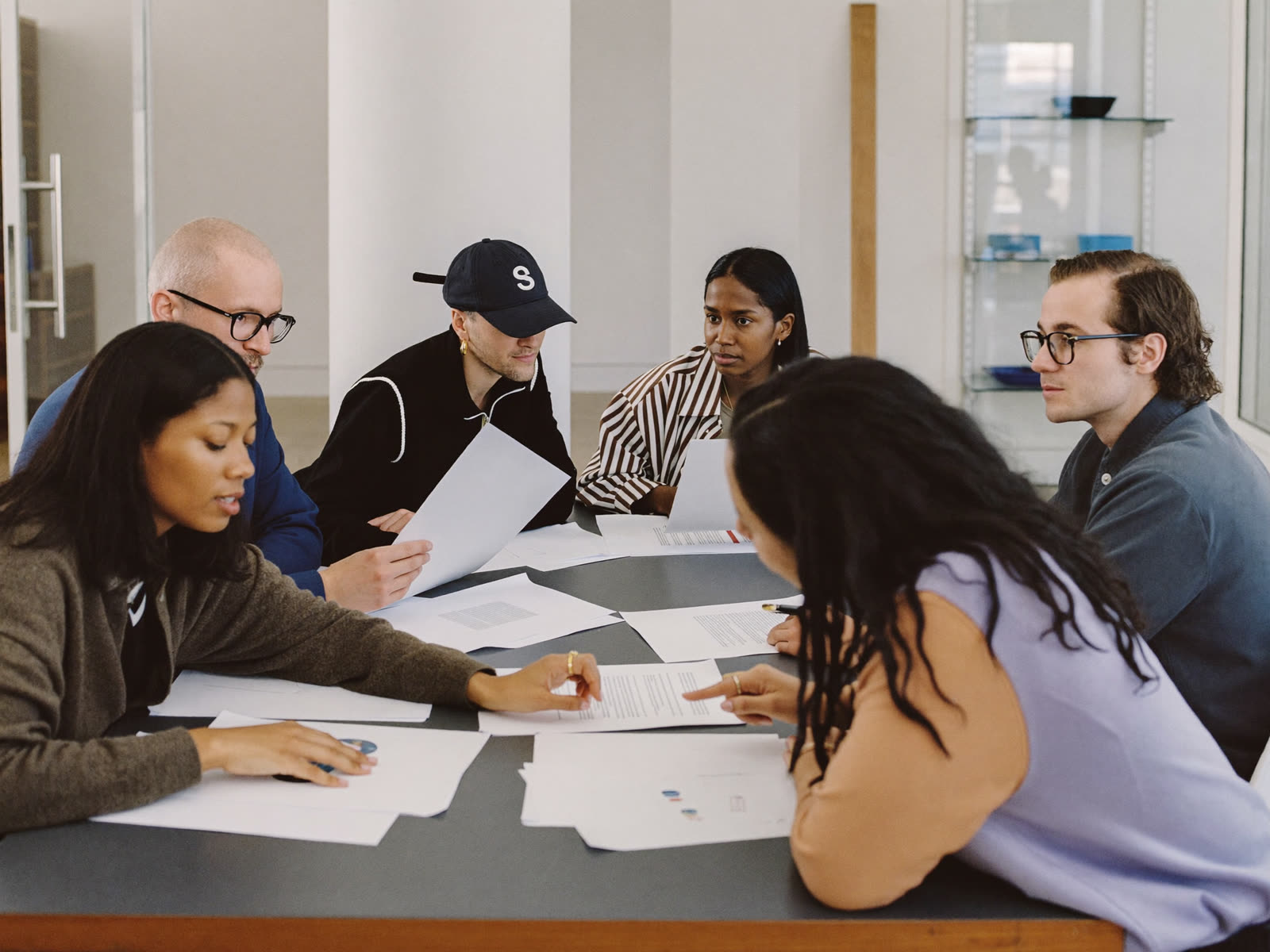 A diverse team working through paperwork around a table