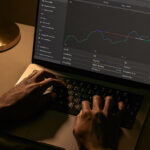 Hands typing on a laptop showing a simple dashboard