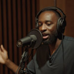A man recording a podcast at a studio microphone