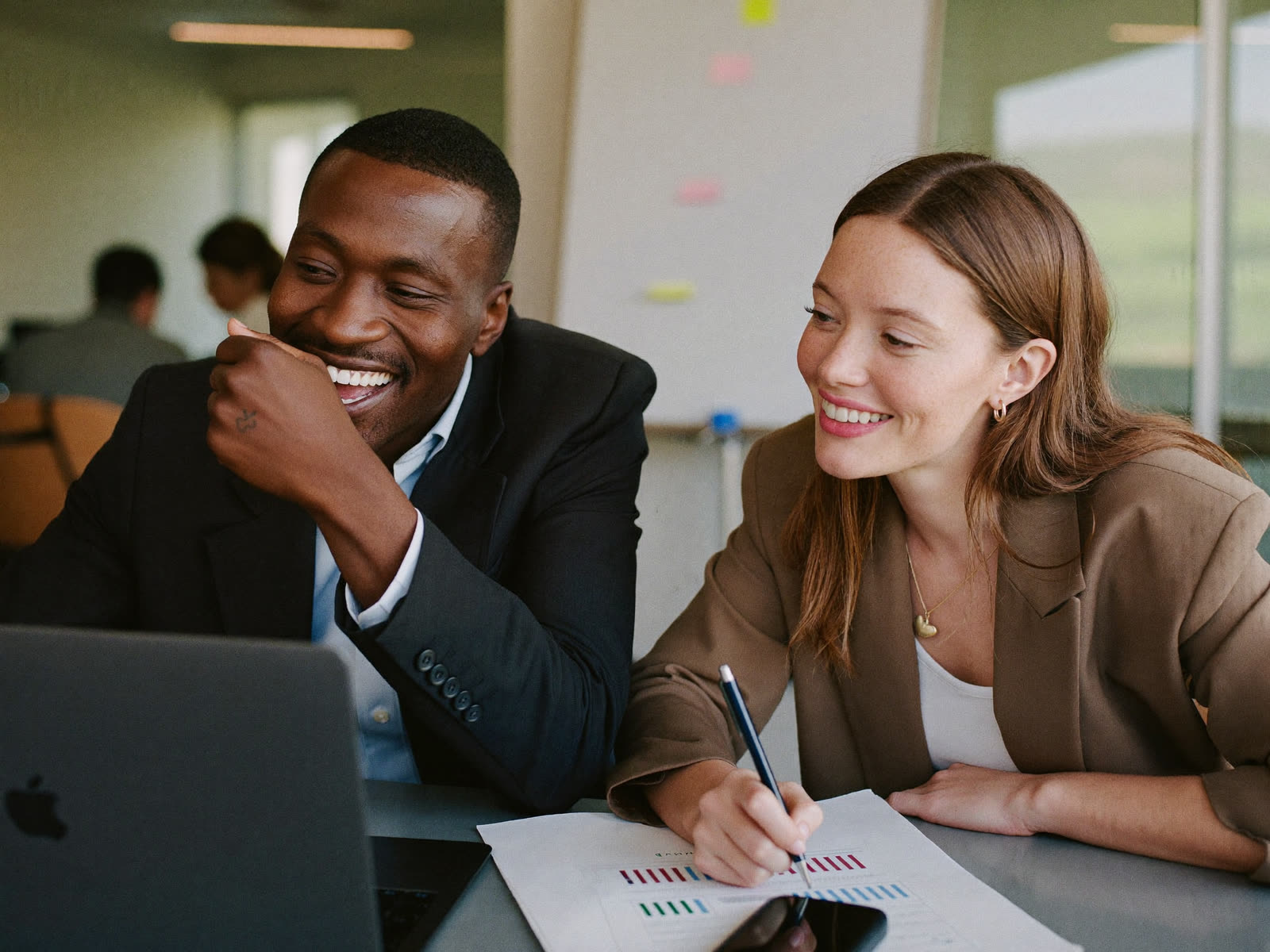 Two colleagues reviewing performance reports together