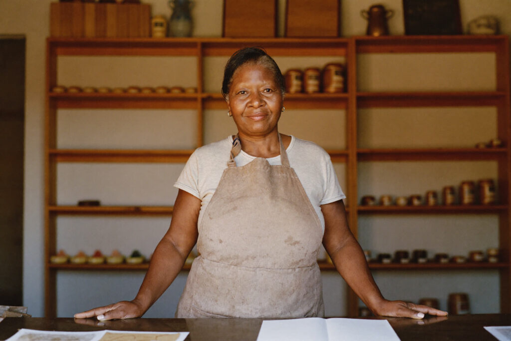 A small business owner standing behind her shop counter ready to answer a customer question