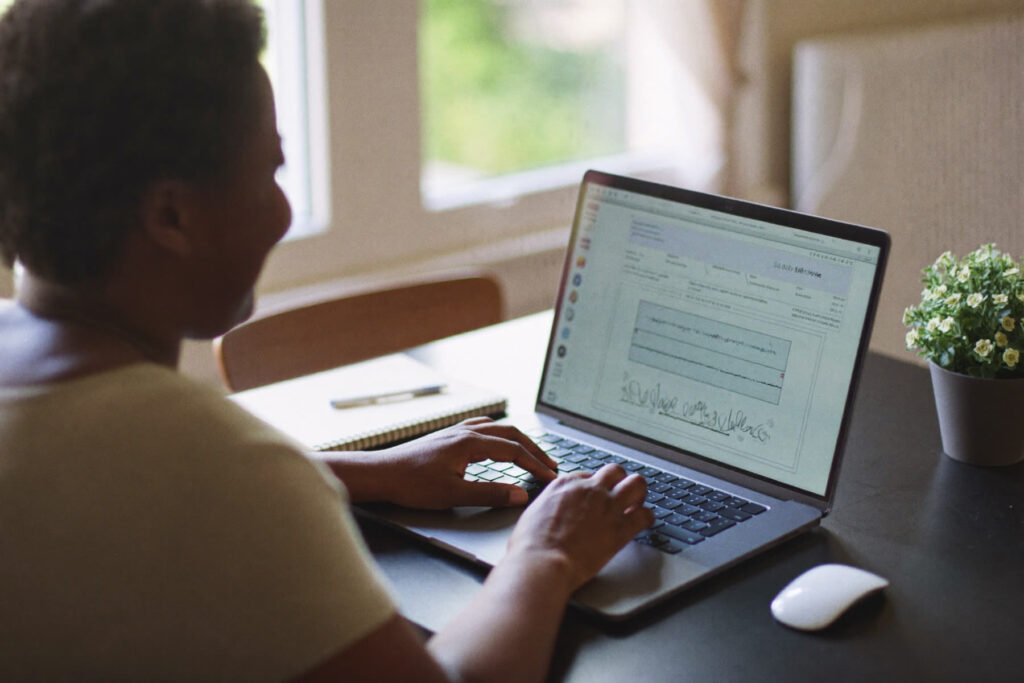 A woman at a laptop in her home office mapping out the questions behind one subject
