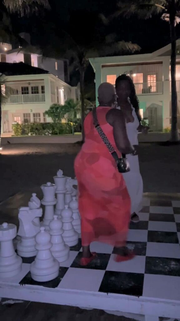 Chicago stepping on a life-size chess board at night in San Pedro, Belize