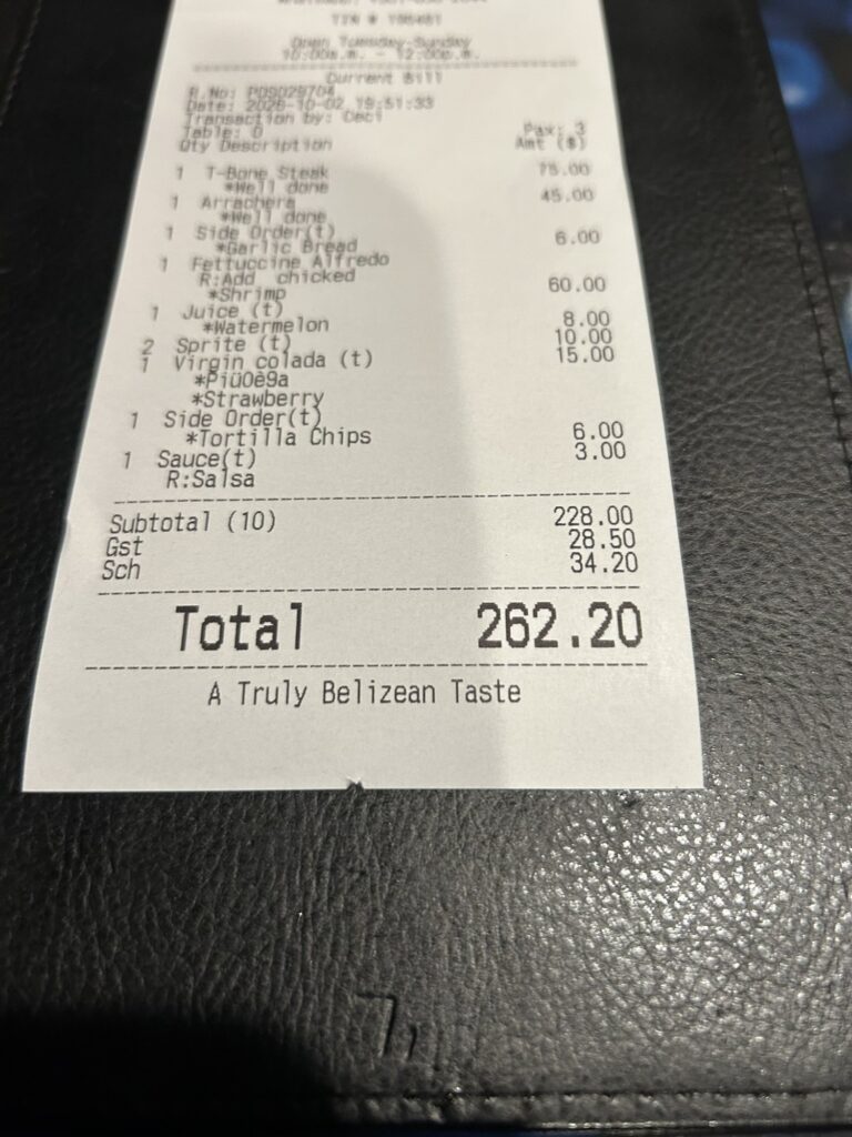 A restaurant bill in Belize dollars showing the total in BZD