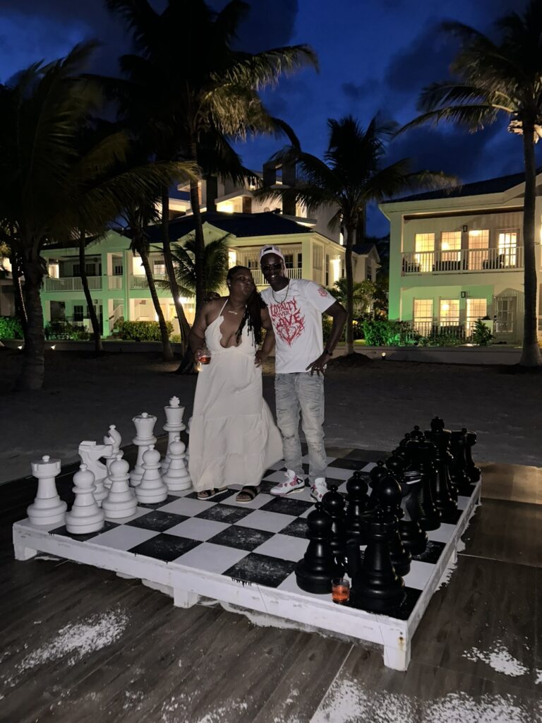 David and Chiquita Hawkins on the life-size chess board at a San Pedro resort at night