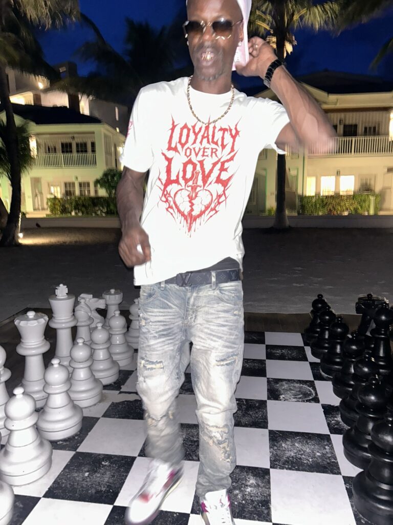 David Hawkins standing on a life-size chess board at dusk in San Pedro, Belize