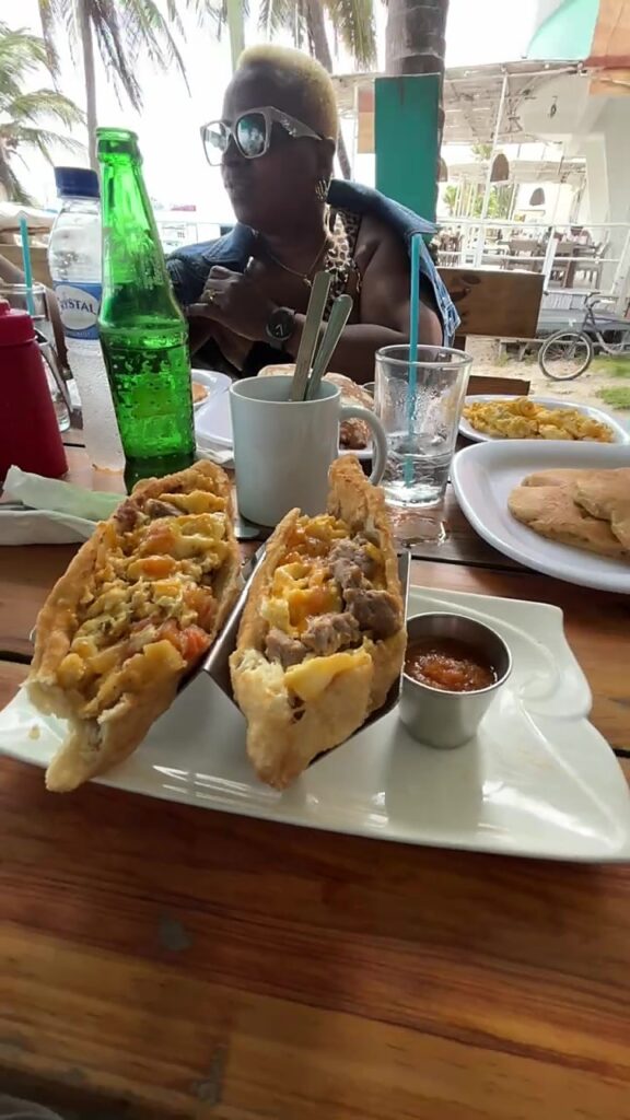 A table at a Belizean restaurant in San Pedro with stuffed fry jacks, salsa and a bottle of Belikin