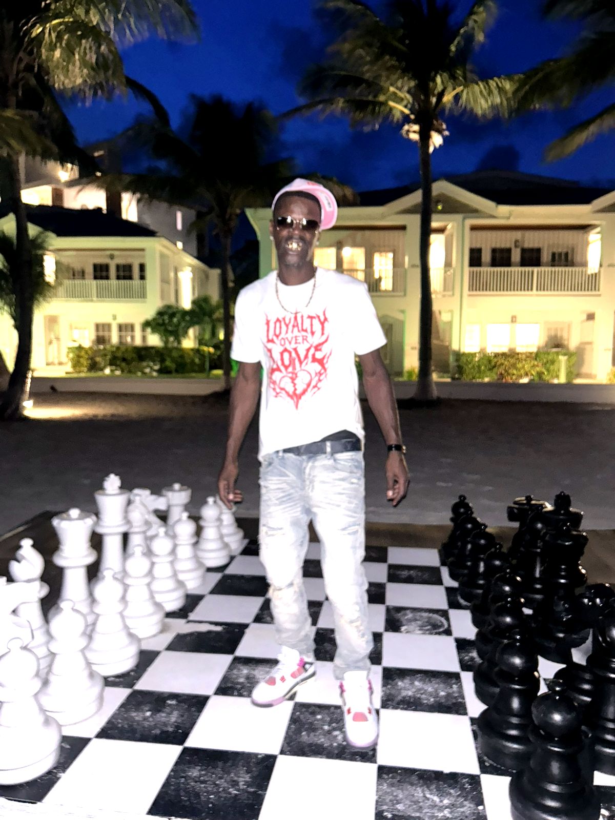 David Hawkins standing on a life-size chess board at dusk in San Pedro, Belize